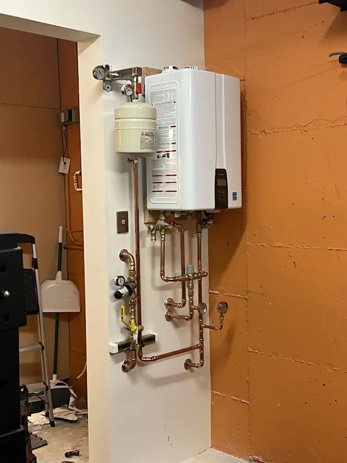 Plumbing technician inspecting water heater connections in Deephaven